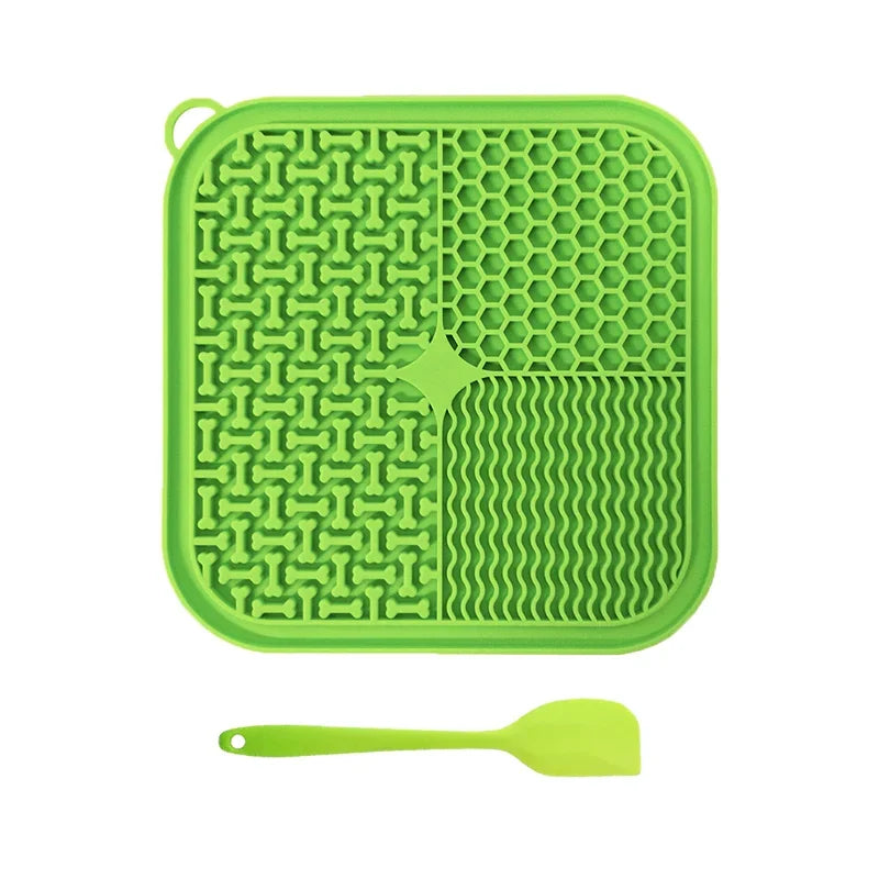 Green silicone licking mat with textured design and a matching spatula on a white background from ThinkyPets