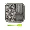 Gray silicone mat with textured patterns and a green spatula on a white background from ThinkyPets