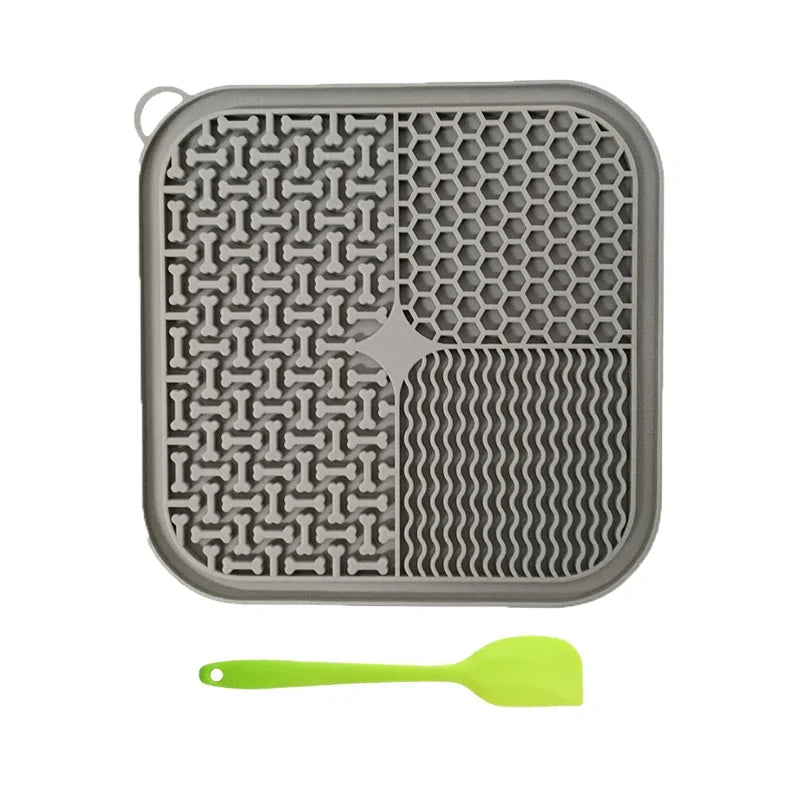 Gray silicone mat with textured patterns and a green spatula on a white background from ThinkyPets