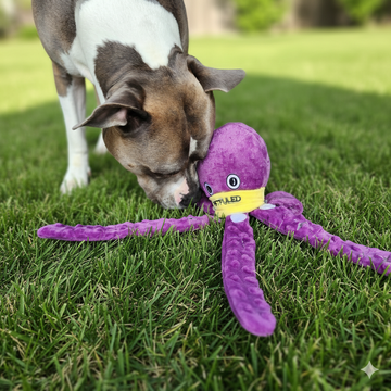 Dog playing with a purple octopus-shaped toy on grass sold by ThinkyPets