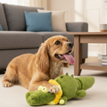Dog playing with a green alligator toy on a white background