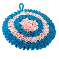 Round, textured dog snuffle matholder with blue and pink ruffled design on a white background