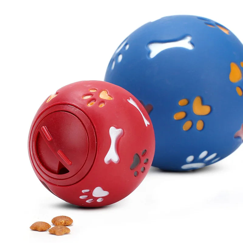 Dog playing with colorful balls on a grassy field