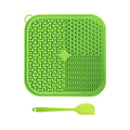 Green silicone mat with textured design and a matching spatula on a white background