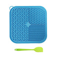 Blue silicone mat with textured design and a green spatula on a white background