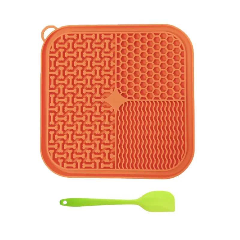 Orange silicone mat with honeycomb pattern and a green spatula on a white background